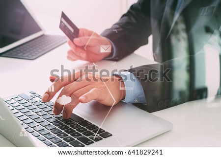 businessman making credit card purchase online with laptop computer on modern desk with VR icon diagram