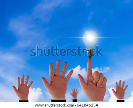 Think different concept, hand and light bulb on blue sky background