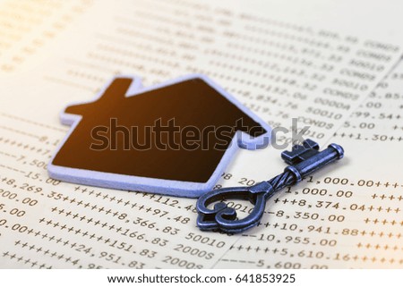 Old key with home model on account book background for finance, Concept of real estate and deal.