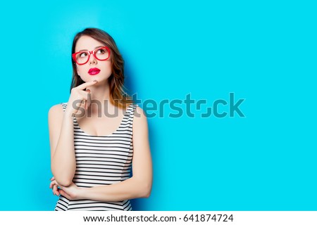 portrait of beautiful young woman in glasses on the wonderful blue studio background Royalty-Free Stock Photo #641874724