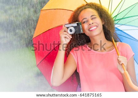 Afro american woman with colorful umbrella and camera