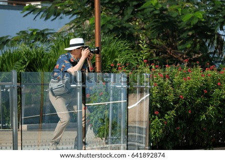 Side view of tourist man wearing hat while taking pictures on the viewpoint in park.