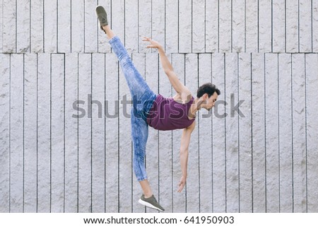 modern dancer in motion performing a ballet pose with jeans