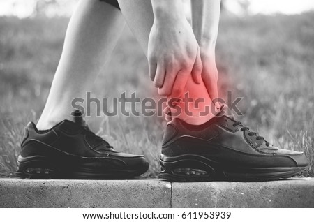 Pain in the ankle. A photo of the legs of a sporty young girl who has a sharp pain in her leg. Side view. Morning run.