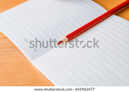 notebook with color pencil on wooden table