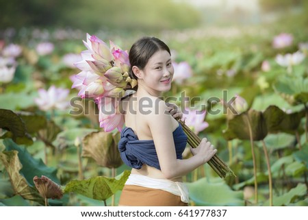 ppicture of beautiful woman with lotus flower,young woman relaxing with beautiful lotus flower field.