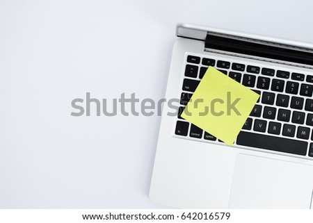 Top view laptop with yellow note post it on white background
