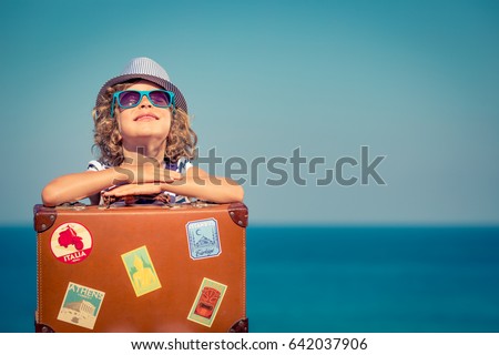 Happy child with vintage suitcase. Kid having fun on summer vacation. Travel and adventure concept
