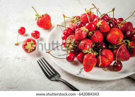 Healthy breakfast, lunch or snack. Summer berries and fruits. Organic fresh cherries and strawberries on a round white marble plate, on a white table. Copy space