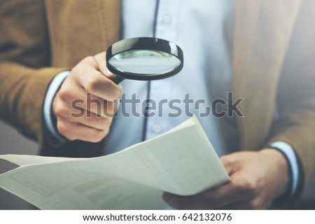 Businessman hand document and magnifier in office Royalty-Free Stock Photo #642132076