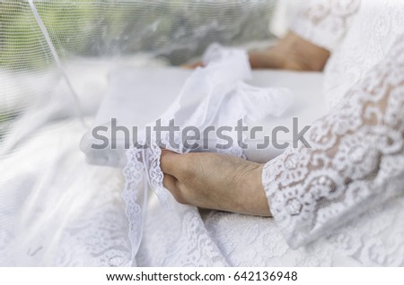 Brunette girl in white dress retro style. Wedding dress lace. The girl luxurious dark ,wavy hair . Posing in the flower garden . In the hands of the book . Eyes closed .  