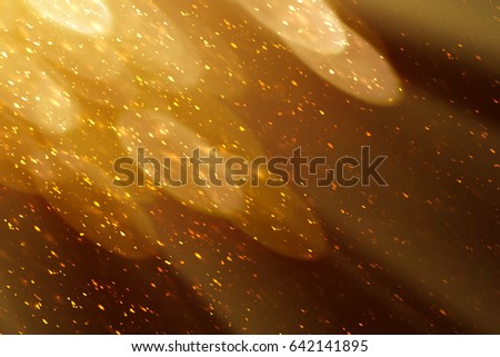 Golden rays and sparkles or glitter lights. Merry Christmas festive background.defocused circle bokeh or particles