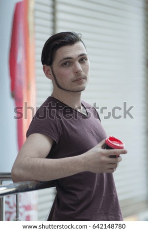 Your morning coffee. Young business man holding a white paper cup with hot coffee in her hands.