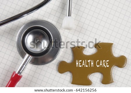 Medical concept with stethoscope,piece of puzzle and coins with HEALTH CARE conceptual text.