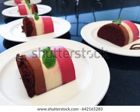 side view of chocolate, strawberry sweet roll on white dish for serve