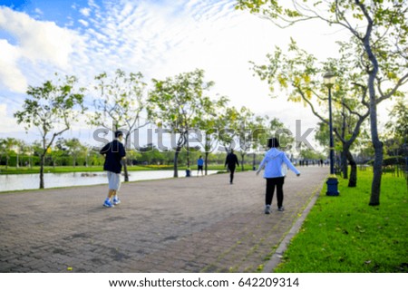 Blurred picture of people are running in the park. 
