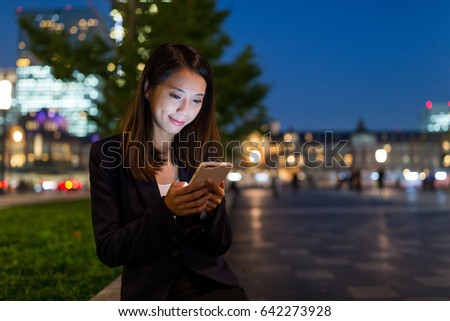 Business woman use of cellphone at night
