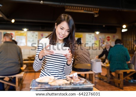 Woman taking photo on her grilled food