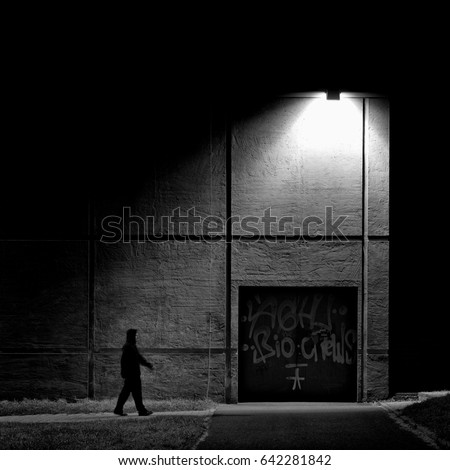 Lonely man walking under the night lamp