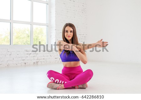 Young athletic girl doing stretching in the gym. The concept of sport and a healthy lifestyle.