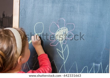 Girl hand holding crayon for drawing on the desk. drawing lessons and creativity for children in kindergarten, child development center. 