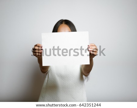 Eastern beautiful girl shows a blank banner for text, isolated on background