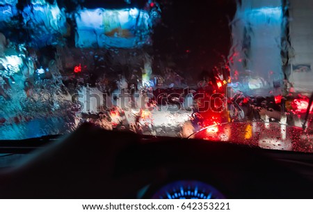 image of people driving car at night time for background usage. (take photo from inside focus on front car windshield)