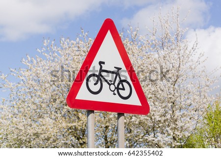 Cycling route sign with blue skies and flower blossoms in the background a useful concept for healthy clean or sustainable transport themes