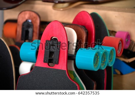 Colorful longboards and skateboards for rent. Photo of flat longboards for sale. Custom painted hand made longboard skateboards in skate shop. Flat colorful longboards