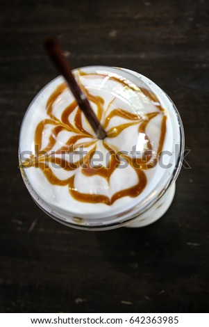 A plastic glass of cappuccino 
