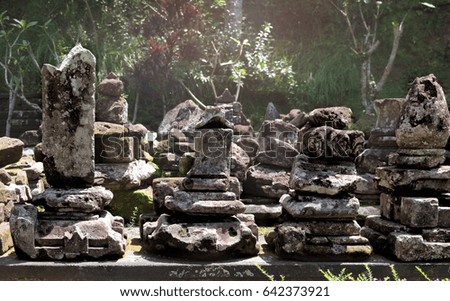 Holy stones in the ancient ruined cave temple Goa Gajah, Ubud, Bali. Decorated stones with bas-relief at hindu sanctuary Elephant Cave in the jungles. Travel Indoneisia