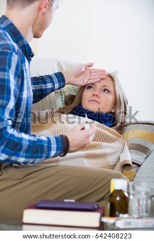 Portrait of sick girl with flue and nursing man indoors
