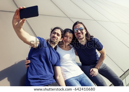 group of three young friends take a selfie on a london terrace