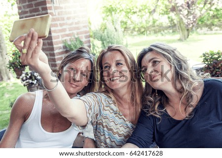 three pretty mature women take a selfie in the countryside