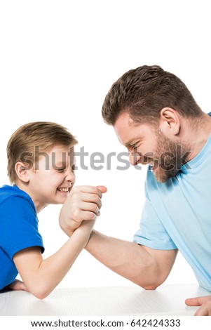 Side view of son with father arm wrestling isolated on white