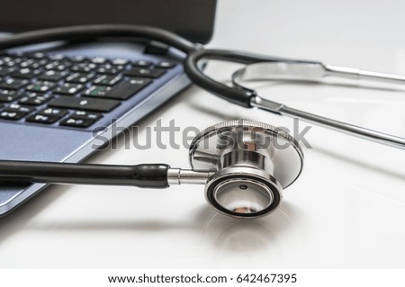 Close-up of stethoscope and laptop computer on white background