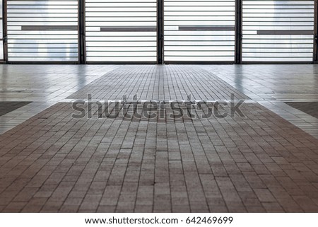 Tiled floor with backlit barred in the background door for concept use