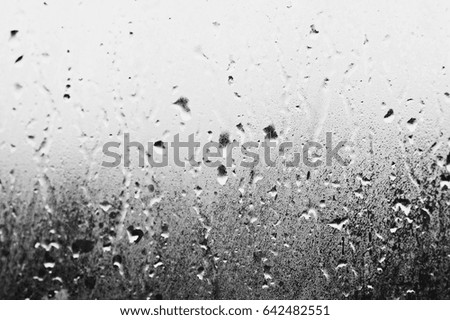 Glass with condensate, natural drops of water on the glass, high humidity, large drops of water drip out of the window, black and white image can be used as a background and texture