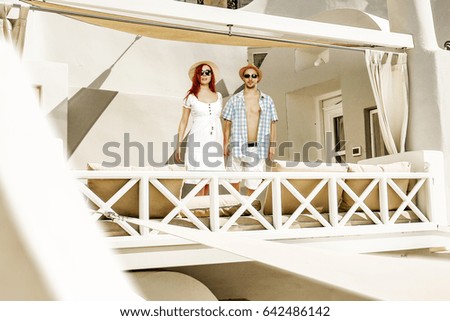 Summer time and two lovers on balcony in santorini hotel 