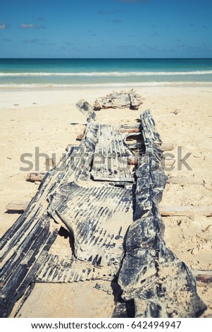 Old abandoned slipway on Macao beach by which pleasure boats can be moved to and from the water. Vertical photo, with tonal correction filter, vintage effect