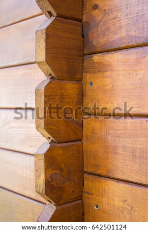 Closeup view of corner of wooden house made of natural logs - wooden construction background