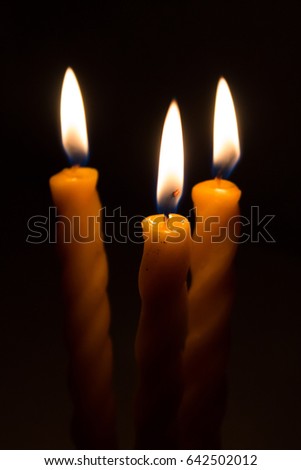 three big burning candles. Bright light on dark background. RIP darkness template. Birthday party. Romantic evening on Valentine.