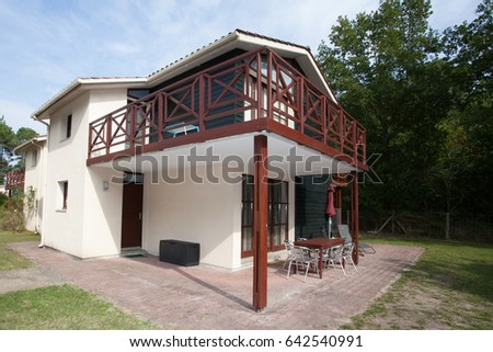 large white and wooden house with a terrace and a huge balcony