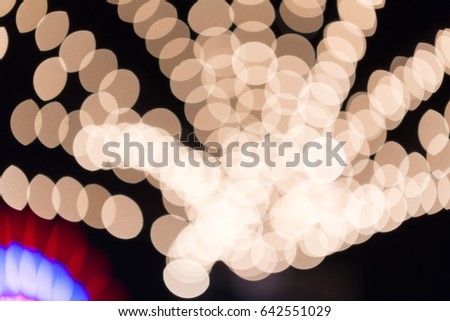 The blurred images of several orange circle lights overlap.