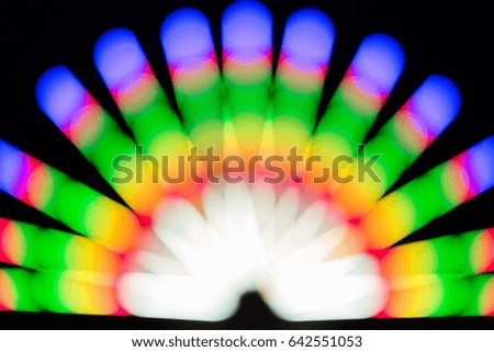 The blur of many colored lights overlaps the background.