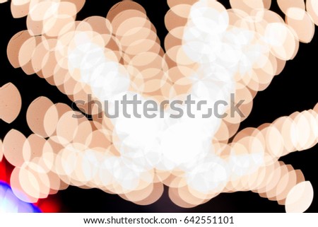 The blurred images of several orange circle lights overlap.
