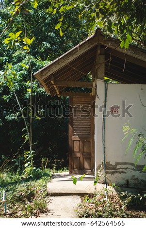 Old public toilet in the park with Thai word on sign