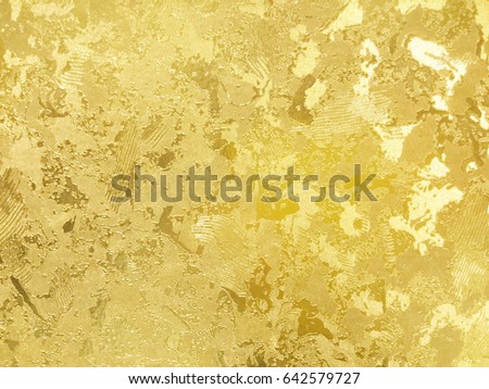 Abstract gold color painted on grunge rough surface of stucco concrete wall. Golden texture background and wallpaper Royalty-Free Stock Photo #642579727