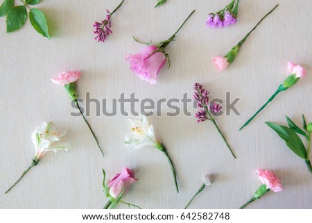 Floristics hobby and work. Floral bouquet making process. Overhead geometric flowers background. Rose, alstromeria, carnation and dried flowers on white table.
