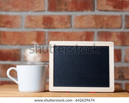 photo of cup of hot fresh coffee and blackboard on the wonderful brick wall background